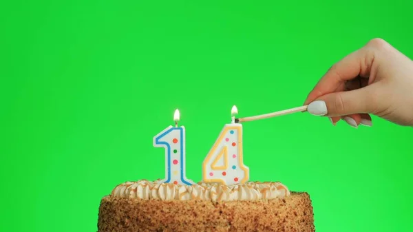 Зажигание свечи на четвертый день рождения на вкусном торте, зеленый экран 14 — стоковое фото