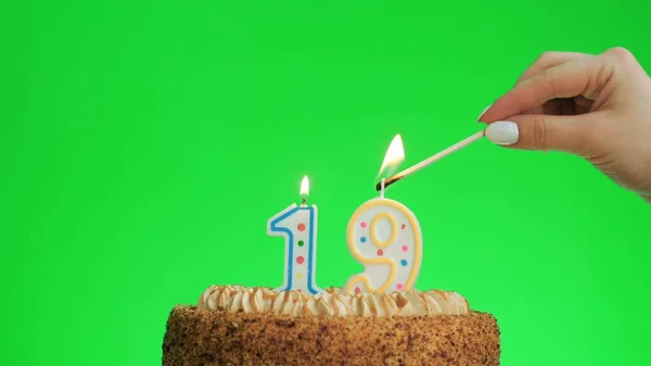 Iluminando uma vela de aniversário número quatro em um delicioso bolo, tela verde 19 — Fotografia de Stock