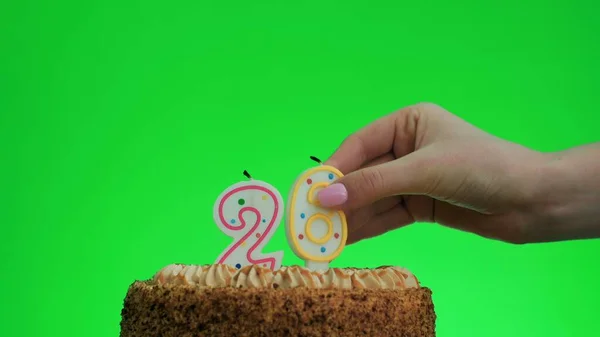 Зажигание свечи дня рождения номер четыре на вкусном торте, зеленый экран 26 — стоковое фото