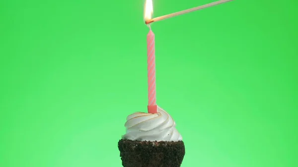 Een blauwe kaars aansteken op een heerlijk cupcake, groen scherm — Stockfoto