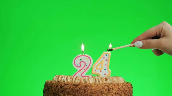 Зажигание свечи дня рождения номер четыре на вкусном торте, зеленый экран 24 — стоковое фото