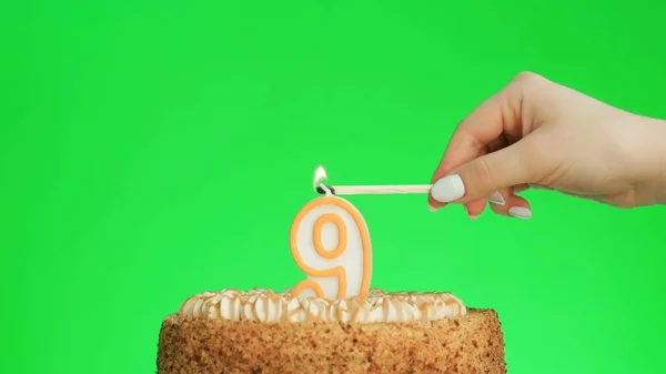 Iluminando uma vela de aniversário número quatro em um delicioso bolo, tela verde 9 — Fotografia de Stock
