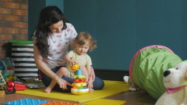 Anne ve kızı çocuk piramidiyle oynuyor.