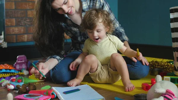 Madre e hija dibujan un cuaderno en el suelo — Foto de Stock