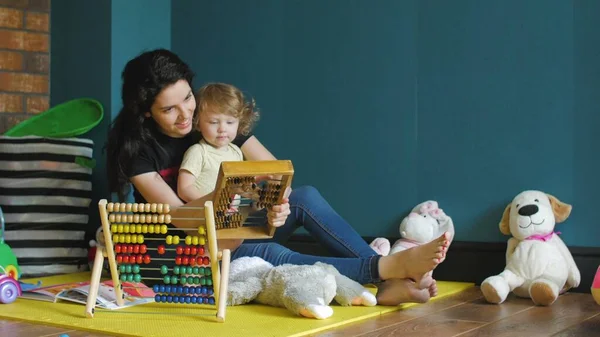 Madre e hija jugando con ábaco de madera — Foto de Stock