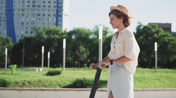 Attractive woman in straw hat ride on the electric kick scooter — Stock Photo, Image