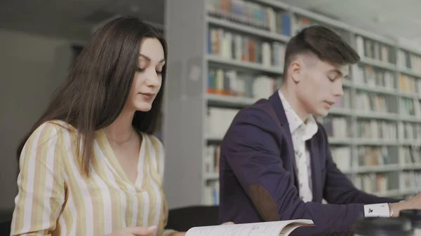 A couple of friends laughing in the library and they love each other as a sign of love and friendship. — Stock Photo, Image