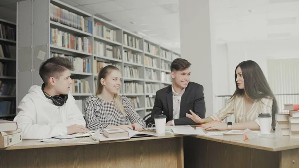 Young Students chat in university library.