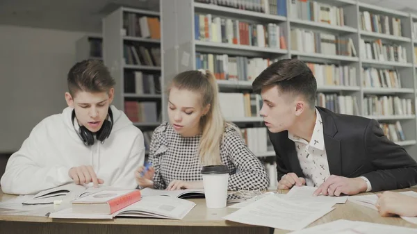 Grupa studentów przygotowująca się do egzaminu w bibliotece uniwersyteckiej. — Zdjęcie stockowe