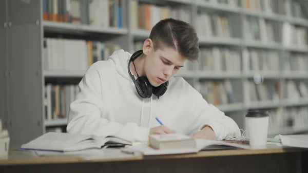 Tipo cansado se queda dormido mientras se prepara para el examen en la biblioteca de la escuela — Foto de Stock