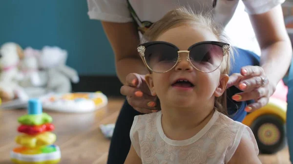 Retrato de cerca de una niña linda y feliz con gafas de sol — Foto de Stock