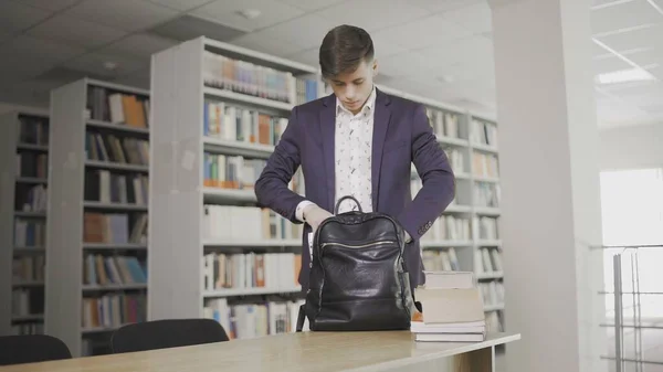 Un joven estudiante vino a la biblioteca. Estudiante universitario haciendo estudios de investigación en biblioteca con libros — Foto de Stock