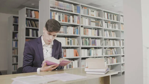 Young student study hard in library. Male university student doing study research in library with books — Stock Photo, Image