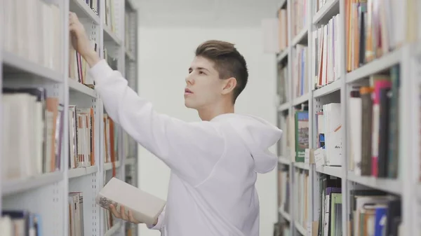 Student taking Books from Bookshelf in Library (Könyvtár) — Stock Fotó