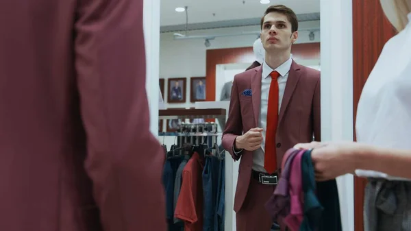 Jonge zakenman kijkt naar de spiegel en probeert op verschillende banden — Stockfoto