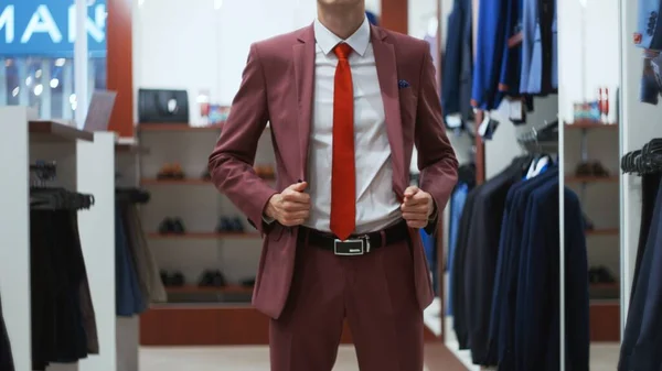 Stylish businessman man trying on a suit jacket in shop — Stock Photo, Image