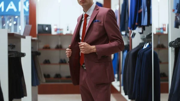 Stylish businessman man trying on a suit jacket in shop — Stock Photo, Image