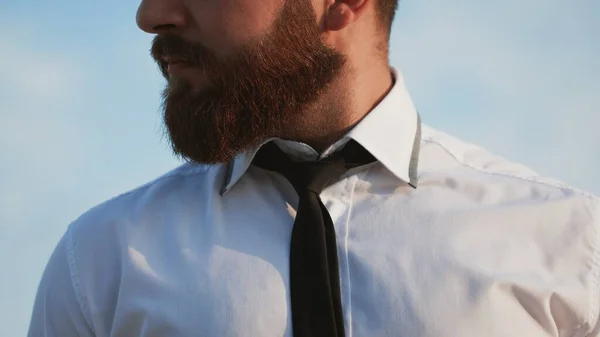 Homem barba de camisa branca amarrando a gravata ao ar livre — Fotografia de Stock