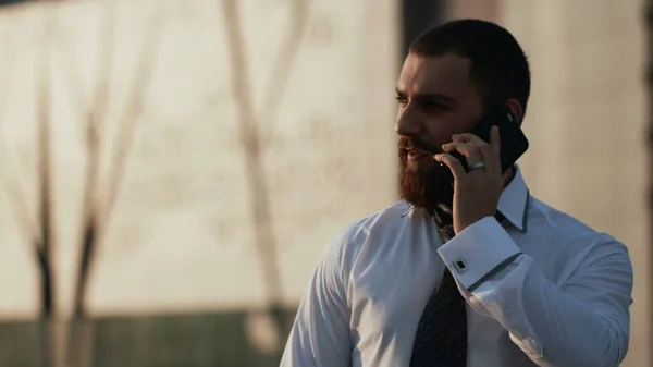 Attractive caucasian businessman using smartphone outdoors — Stock Photo, Image