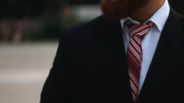 Бізнесмен зв'язує краватку на відкритому повітрі в парку — стокове фото