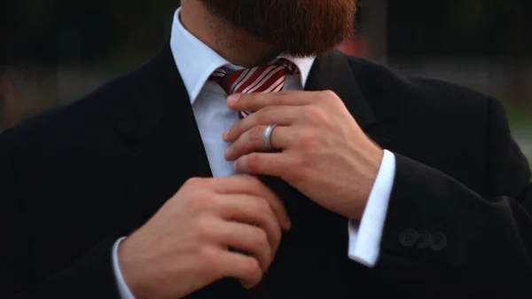 Businessman tying the necktie outdoors in the park — Stock Photo, Image