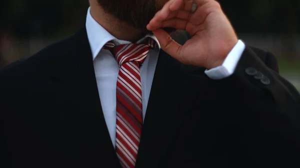 Businessman tying the necktie outdoors in the park — Stock Photo, Image