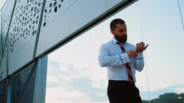 Empresario en camisa blanca atando la corbata y mirando a la cámara — Foto de Stock