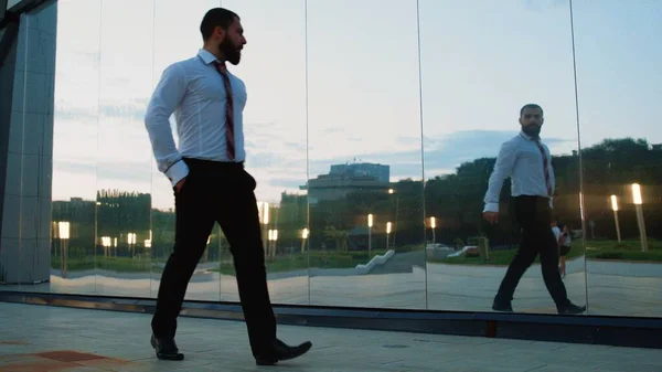 Hombre de negocios guapo caminar en el parque y atar la corbata — Foto de Stock