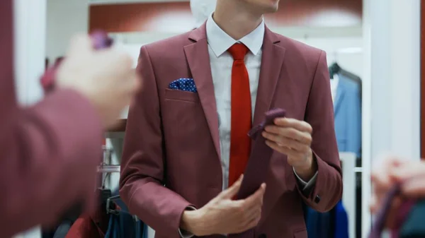 Zakenman proberen op verschillende stropdassen in de winkel — Stockfoto