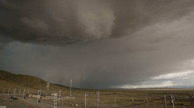 Gök gürültüsü mavi gökyüzünü kaplamadan önce devasa kara bulutlar Tibet