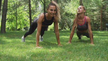 Yoga yapan iki kız aşağı bakan köpek.