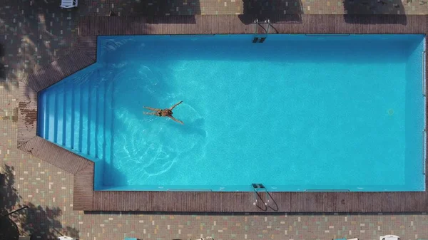 Vista superior de mujer joven delgada en bikini está flotando en aguas cristalinas — Foto de Stock