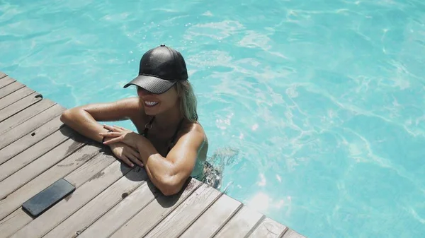 Hermosa mujer en sombrero negro es relajante en la piscina —  Fotos de Stock