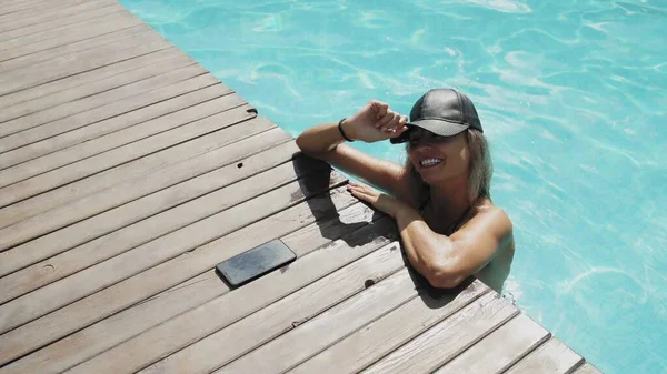 Bella donna in cappello nero è rilassante in piscina — Foto Stock