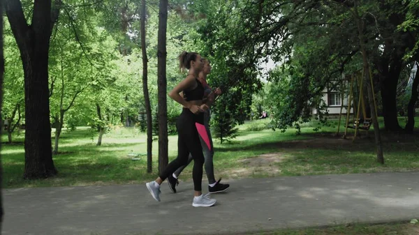 Dos mujeres jóvenes corriendo en el parque — Foto de Stock