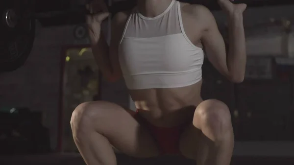 Krásná sportovní žena dělá squat cvičení v tělocvičně — Stock fotografie