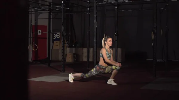 Athletic active woman robi ćwiczenia rozciągające w Loft Style Industrial Gym — Zdjęcie stockowe