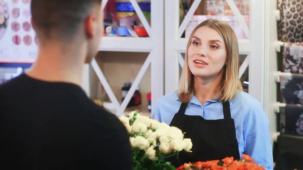 The girl florist is selling a bouquet to the Man florist owner of shop — Stock Photo, Image