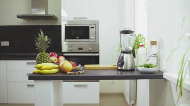 Taze meyve ve mikser masada. Muz, elma, portakal, ananas ve üzüm.