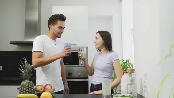 La familia joven por la mañana bebiendo el batido hortalizas de las frutas con la leche para el desayuno tienen una vida sana y el cuerpo — Foto de Stock