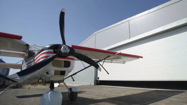 Weißes und rotes Flugzeug in der Nähe des Hangars — Stockfoto