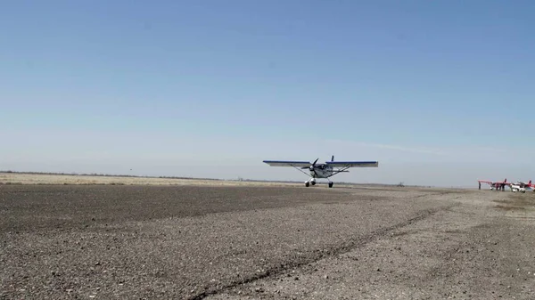 Uçak havalanıyor, havalanıyor. Terk edilmiş havaalanından küçük bir uçak kalkıyor.