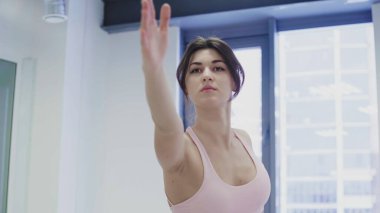 Güzel genç kadınlar, hafif çatı katı tarzı sağlık merkezinde yoga esneme kompleksi yapıyorlar..