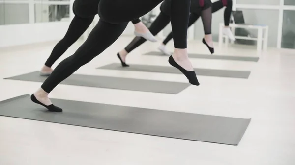 Mujeres jóvenes está practicando aero yoga en club deportivo. mujeres estira las piernas —  Fotos de Stock