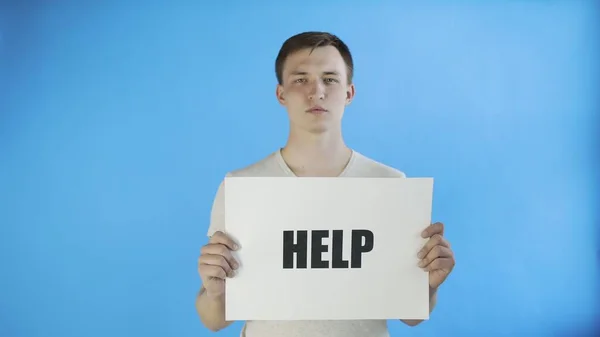 Young Man Activist With HELP Poster on blue background — Stock Photo, Image