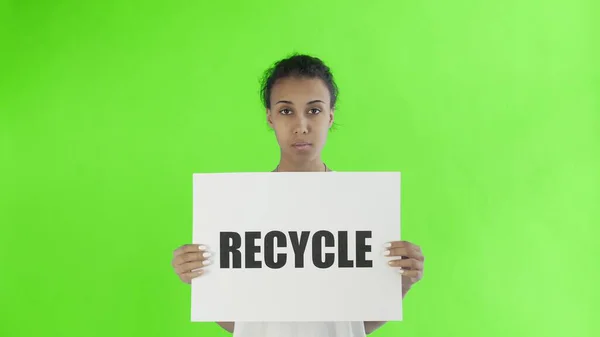 Афроамериканская девушка-активистка с плакатом "Recycle" показывает большой палец на фоне хроматического ключа — стоковое фото