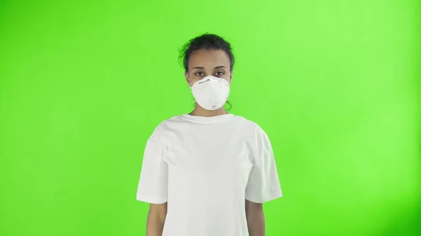 Joven afroamericana chica usando mascarilla en croma clave fondo —  Fotos de Stock