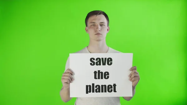 Молодой человек-активист с плакатом "Спаси планету" на фоне хромы — стоковое фото