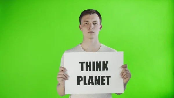 Молодой человек-активист с плакатом Think Planet на фоне хроматического ключа — стоковое фото