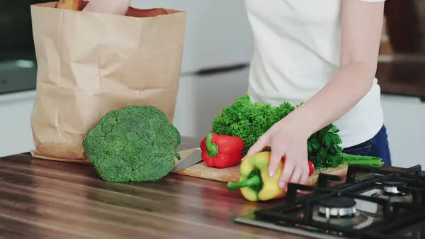 Modern mutfaktaki market poşetlerini sebzelerle boşaltan kadınların yakın plan fotoğrafları..